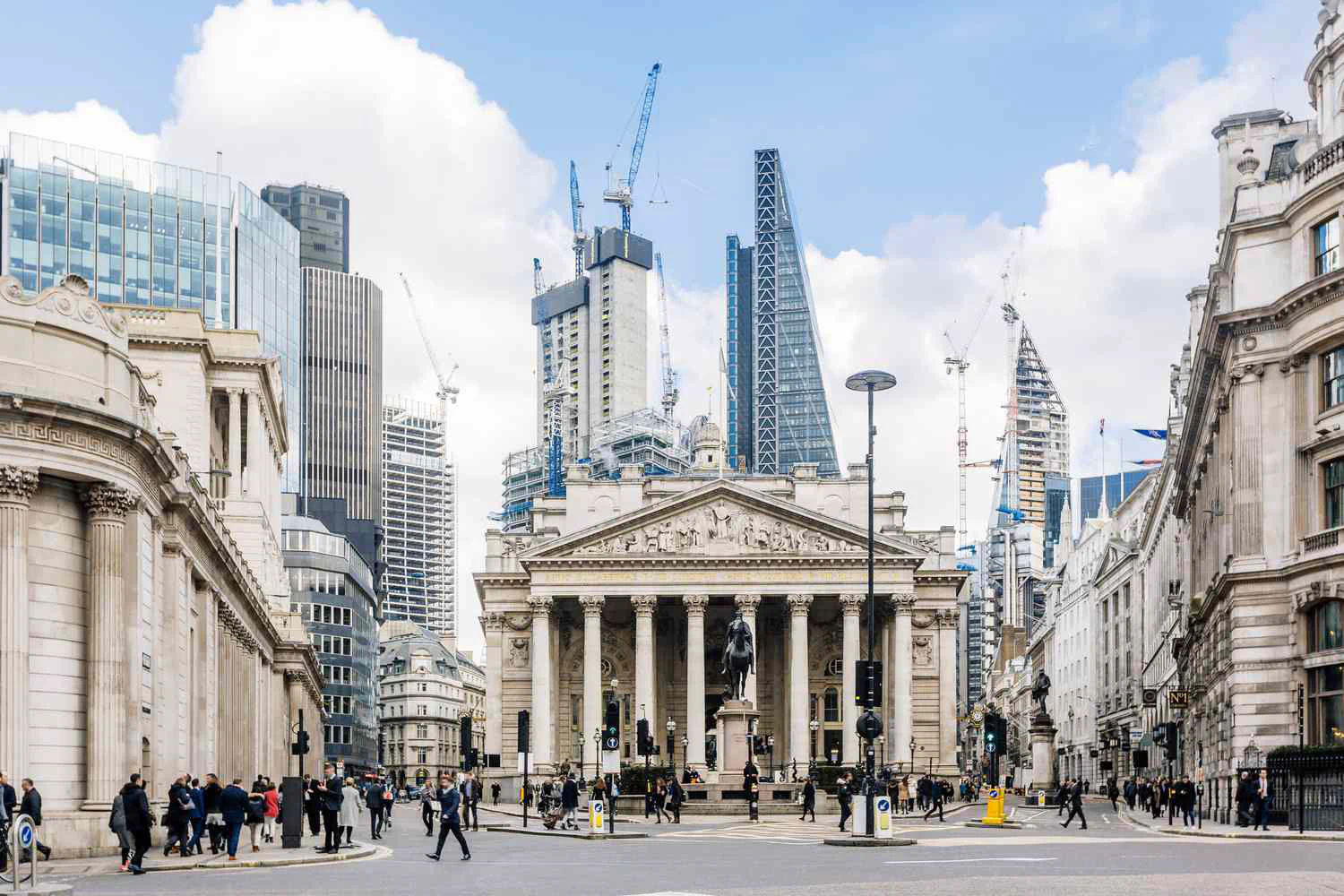 The Royal Exchange and the Bank of England in the City of London, with office towers and pedestrians.