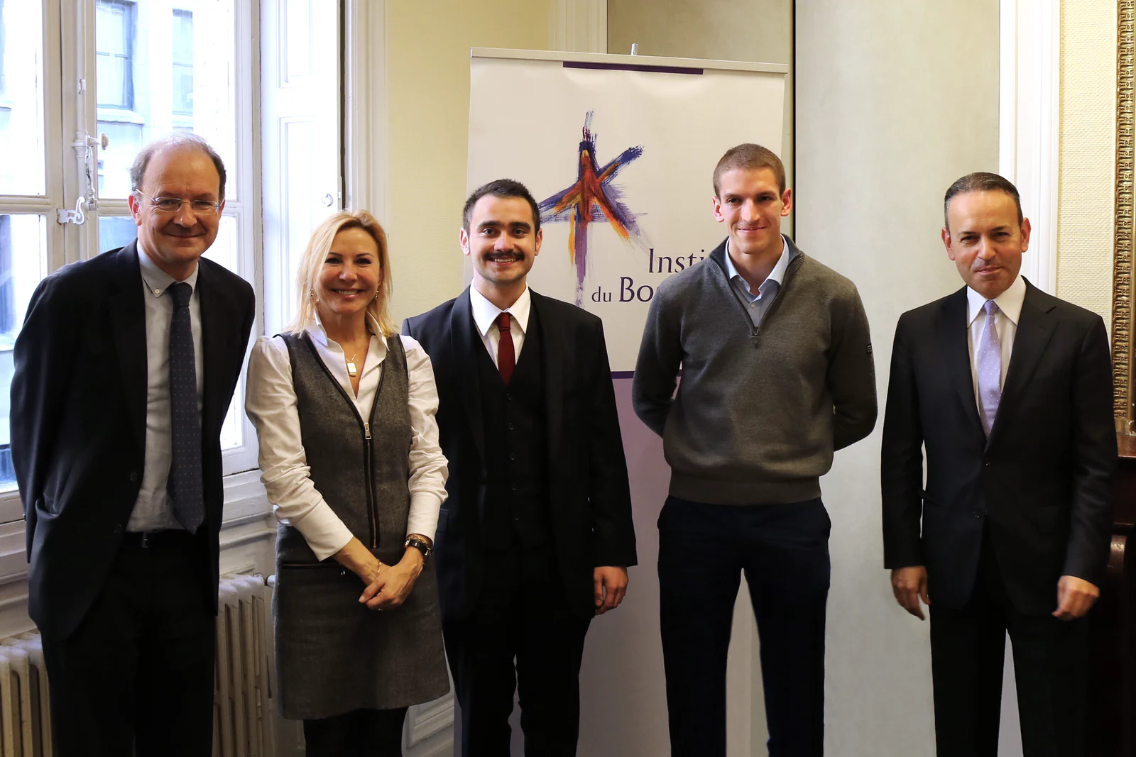 Five people at an Institut du Bosphore event in Paris, standing in front of the institute's banner.